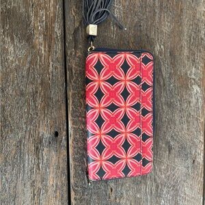 Stella & Dot wallet with red and navy blue pattern and a blue leather tassel.